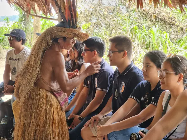 Indígena amazónico pintando el rostro de turistas como parte de una experiencia cultural con Aventourexpeditions