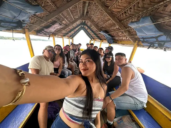 Grupo de turistas tomando una selfie en un bote durante su aventura en el Amazonas con Aventourexpeditions