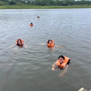 Turistas disfrutando de un baño refrescante en el río Amazonas con chalecos salvavidas.